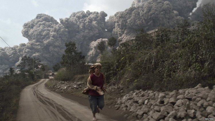 A local villager runs from the eruption of Sinabung volcano in Indonesia. Image credit: BBC News.